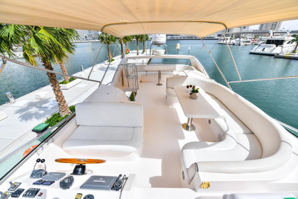 A Luxury yacht in Dubai with a white interior and a dock in the background
