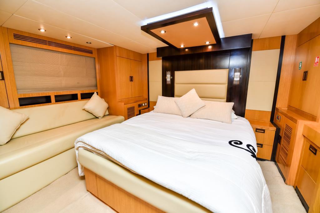 A bedroom on a luxury yacht with a bed and a couch