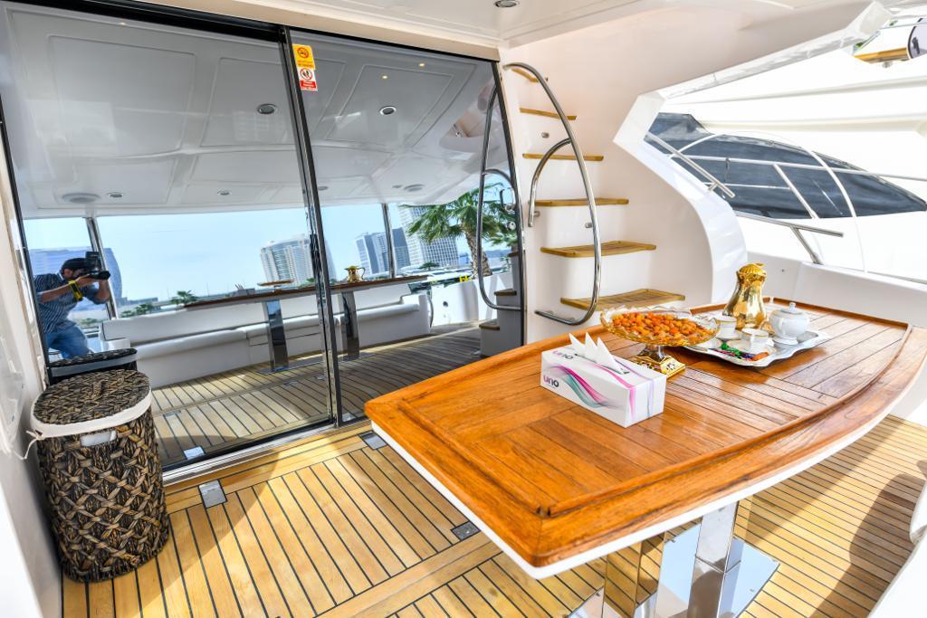 A yacht with a table and chairs on the deck for dinning