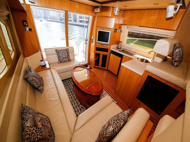 The interior of luxury yacht with couches and a kitchen