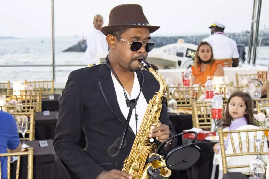 A man playing a saxophone at an event on Dhow Cruise Dubai